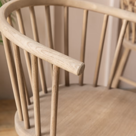 Close up of backrest on vintage inspired wooden carver chair with curved back and spindles.