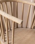 Close up of backrest on vintage inspired wooden carver chair with curved back and spindles.