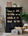 Black shelving unit filled with kitchen crockery, pantry items and farmhouse accessories.