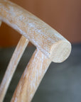Close up of white washed patina finish on frame of wooden dining chair.