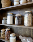 Close up of shelving and pantry items on natural wooden wall cabinet.