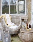 rattan armchair and table with wine and lanterns.