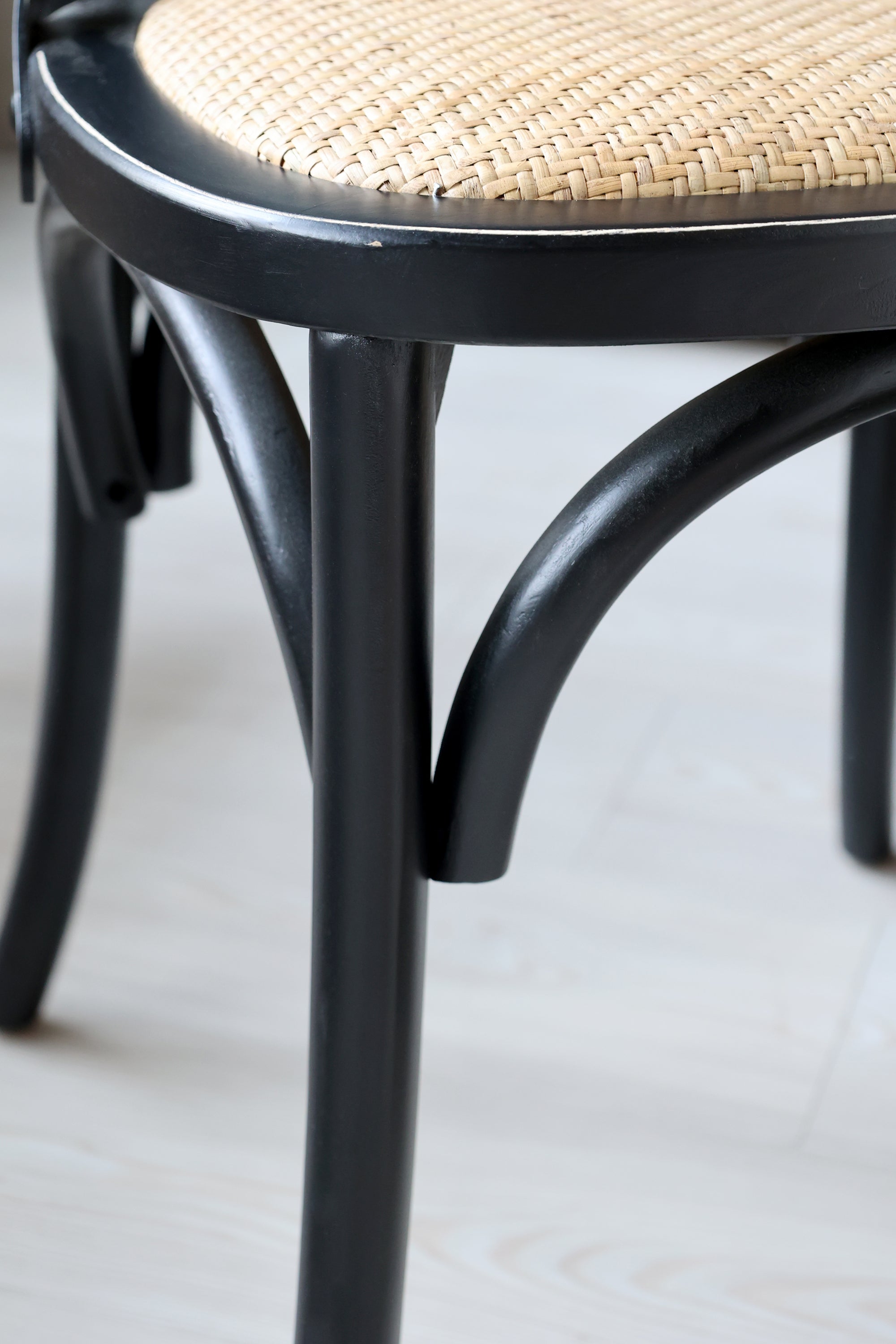 Close up of French style legs on black wooden dining chair.