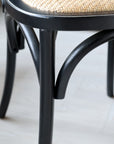 Close up of French style legs on black wooden dining chair.