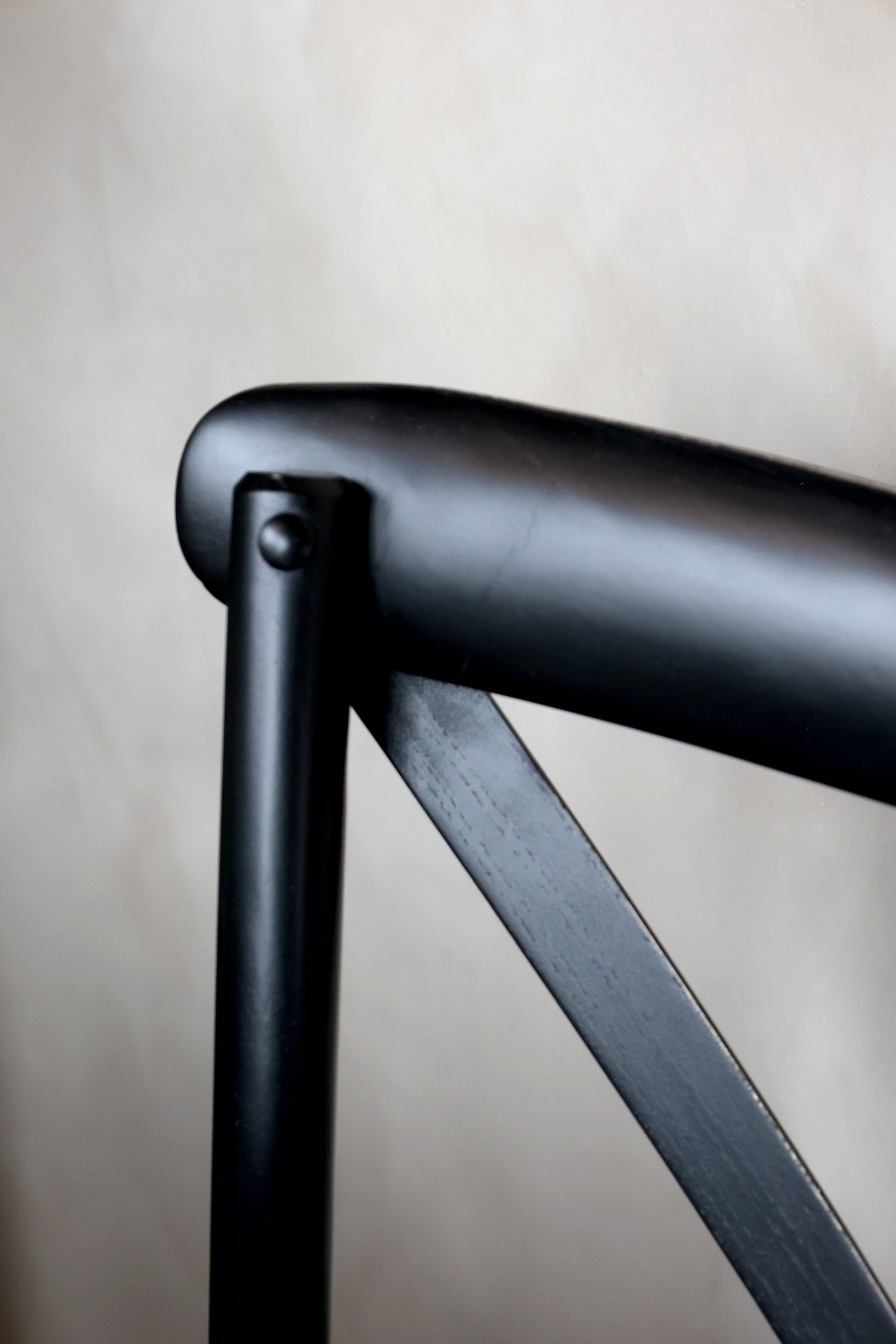 Close up of frame on black wooden dining chair.