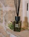 Green florist Sences mini reed diffuser on stone windowsill.