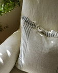 Close up of cream and blue striped cushion with bow tie detailing.