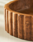 Wooden bowl with textured rim on a light background