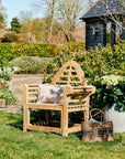 Wooden garden bench with a striped cushion in a garden setting
