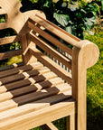 Wooden bench with a patterned seat in a garden setting
