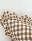 Close up of ruffled edge on brown gingham linen cushion.