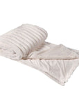 Cream faux fur throw, rolled up with one size folded over.