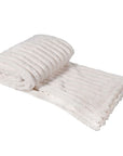 Cream faux fur throw rolled up.