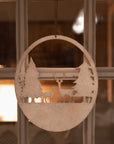 Reindeer scene hanging decoration on a window.