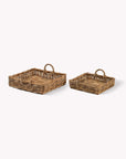 Two natural woven trays on a white background
