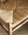 Close-up of a woven wishbone dining chairs with natural wood frame
