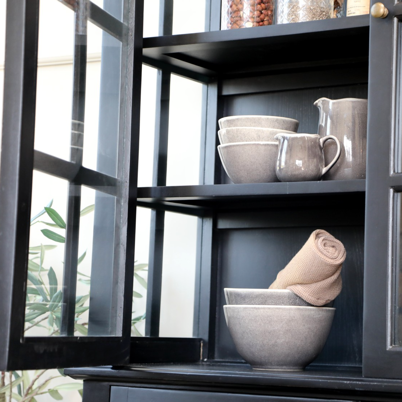Black Armoire displaying crockery.