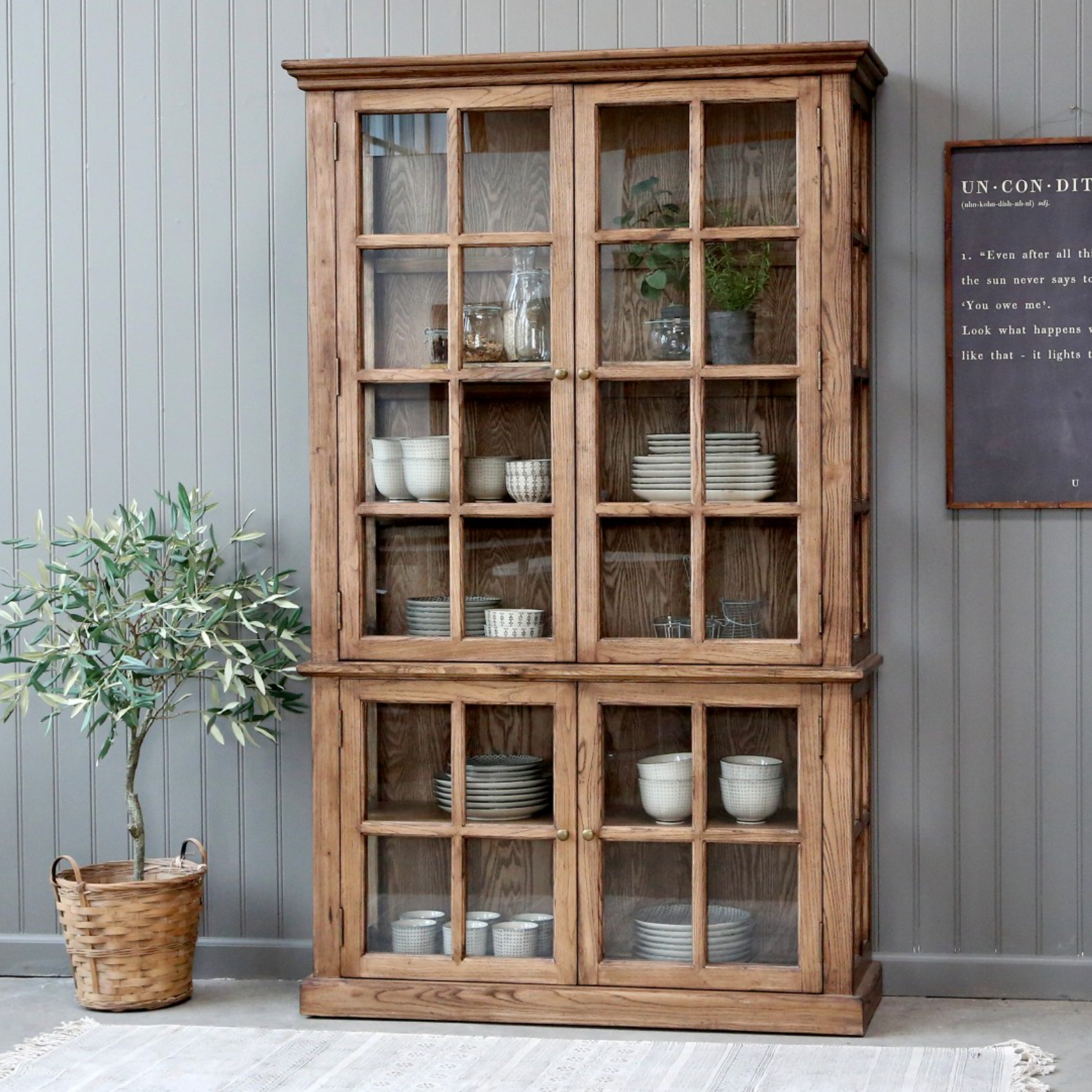 a wooden armoire displaying crockery and kitchen items.