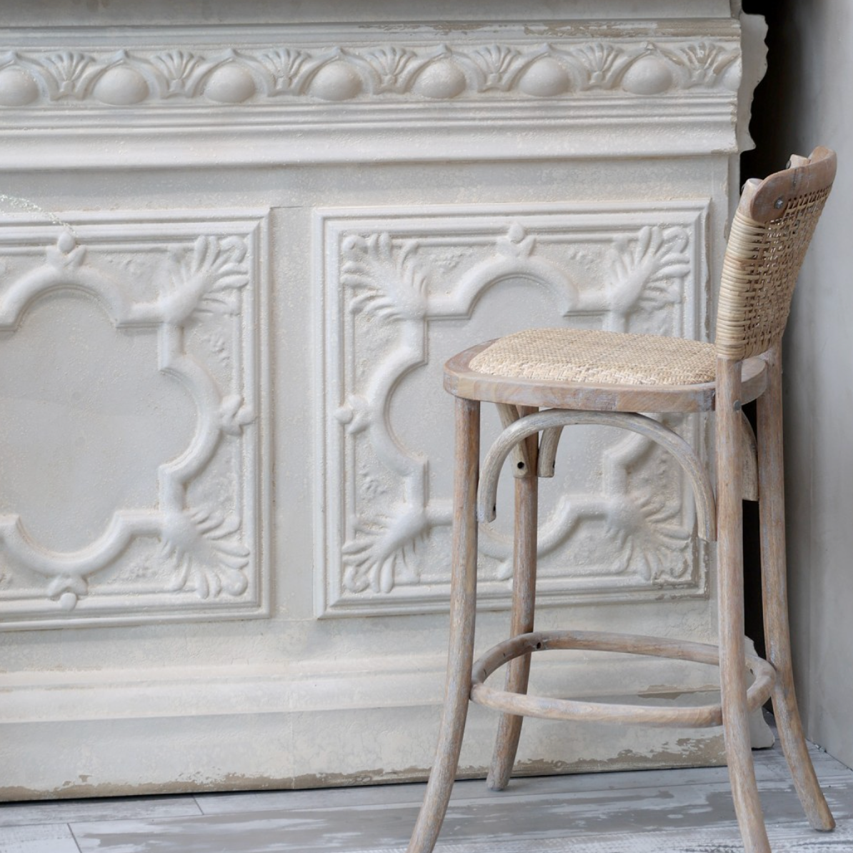 Wicker bar stool and cream ornate bar.