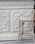 Wicker bar stool and cream ornate bar.