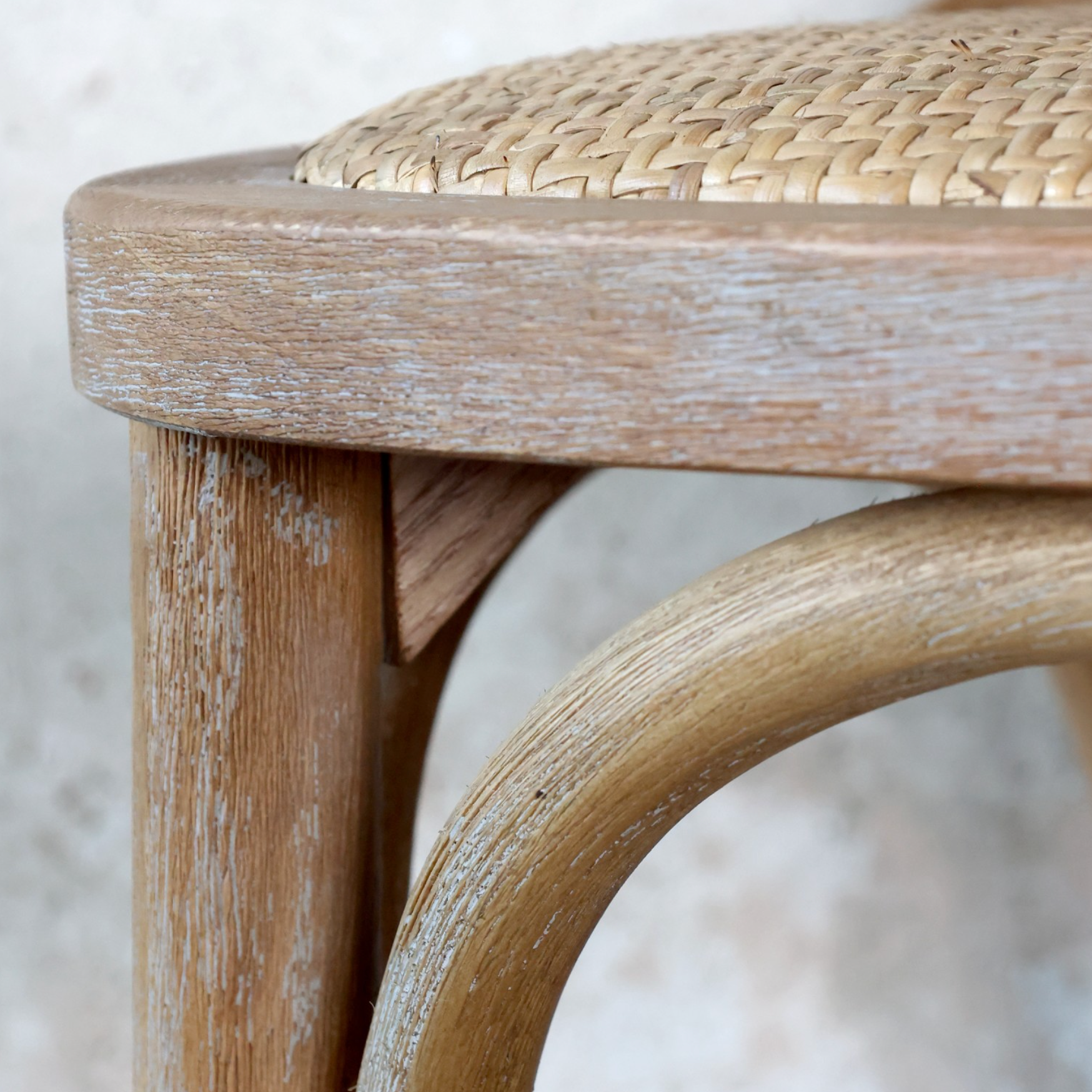 white washed detail of a wooden bar stool.