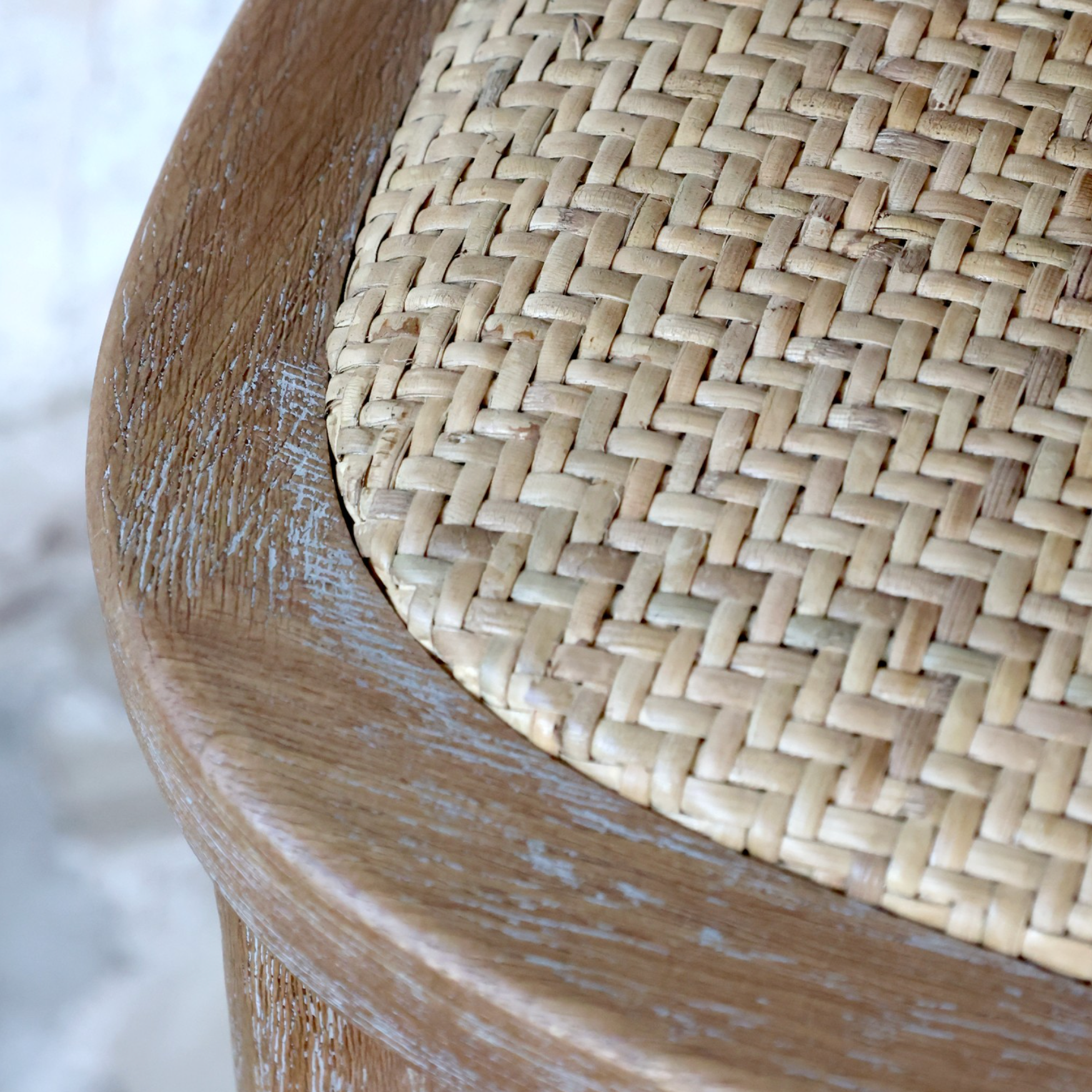 wicker seat on a wooden bar stool.