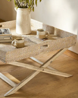 Close up of rattan tray coffee table in bedroom with plant and mug on.