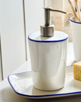 White and blue stoneware soap dispenser.