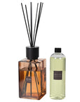 Amber reed diffuser with reed diffuser refill bottle with brown label.