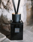 Sences Alang Alang Onyx Reed Diffuser on stone hearth.