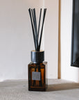 Sences Amber Mini Reed Diffuser on stone mantle.