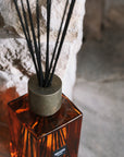 Detail shot of Sences Sienna reed diffuser on stone hearth.