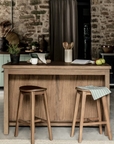 Wooden kitchen island with two bar stools and accessories