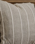 Close up of striped neutral coloured square cushion.