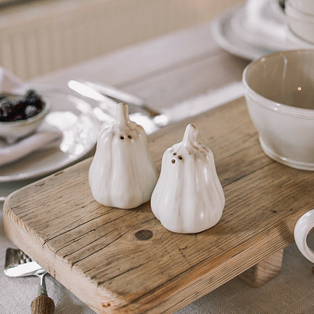 butternut squash salt and pepper shakers on a neutral table with wooden serving board.