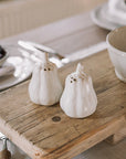butternut squash salt and pepper shakers on a neutral table with wooden serving board.