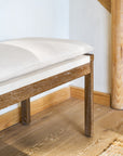 Wooden bench seating with cushions on a wooden floor.
