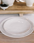set of ceramic dinner plates on oak table.