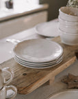 stack of ceramic plates on wooden table.