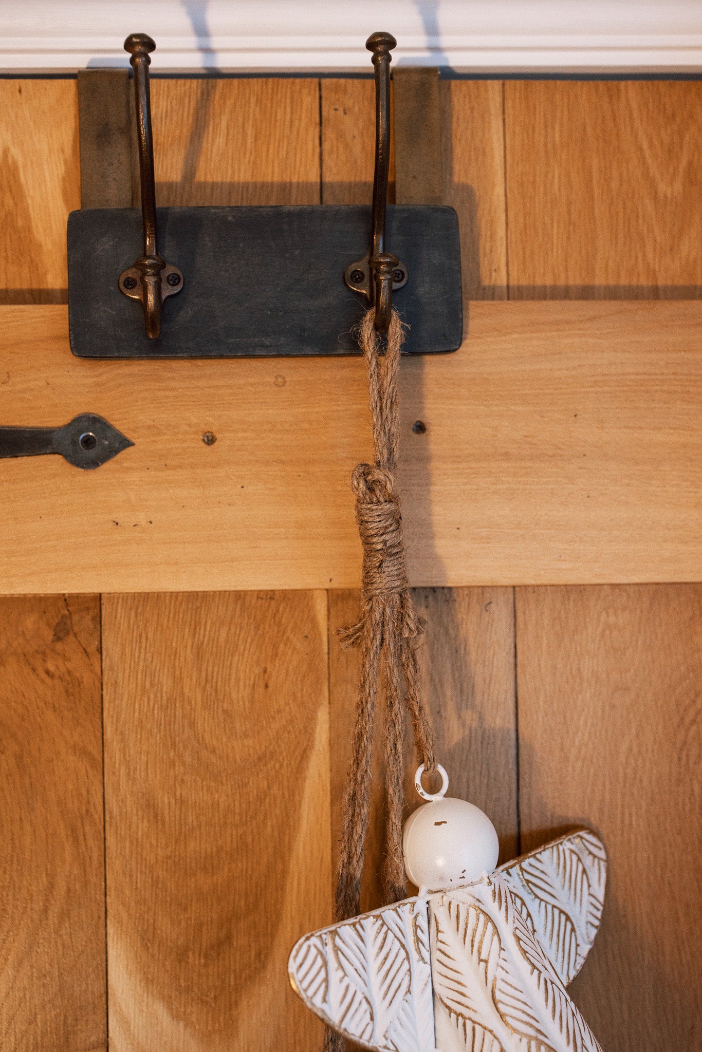 White and gold christmas angels hanging decoration on wooden door.