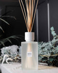 Sences Alang Alang White Extra Large Reed Diffuser with greenery and black background on white console