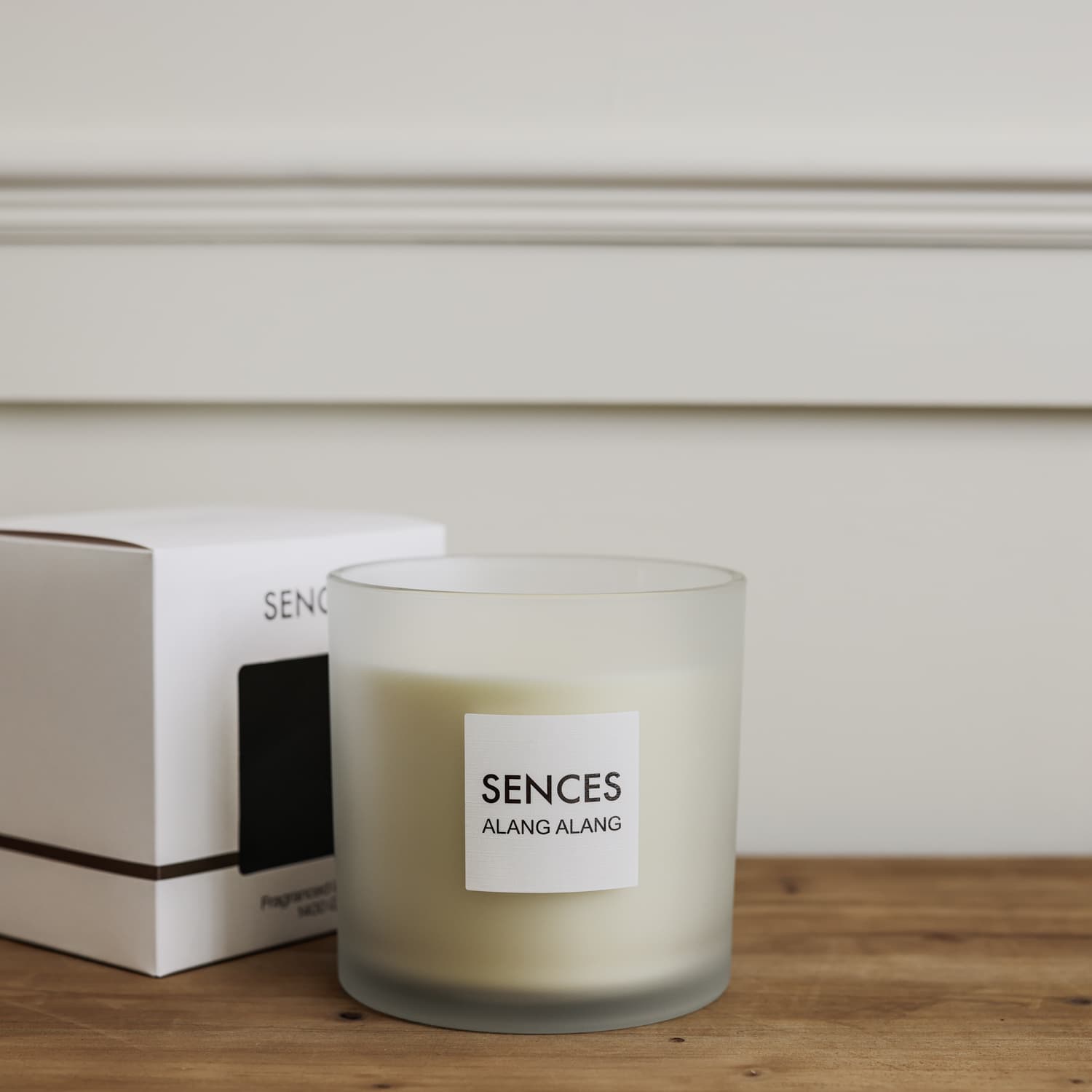 Sences Alang Alang White three wick candle in frosted glass on wooden table with presentation box.