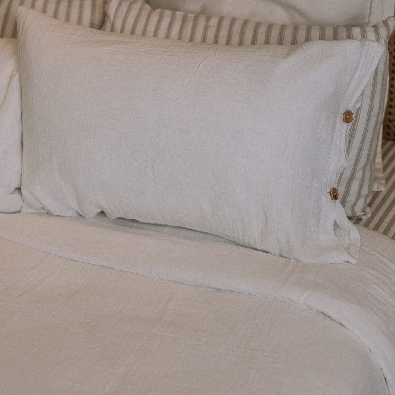 White and striped bedding with buttons.