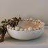 Cream ceramic bobble bowl with purple foliage.