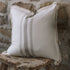 Grey and cream striped cushion on wooden stool.
