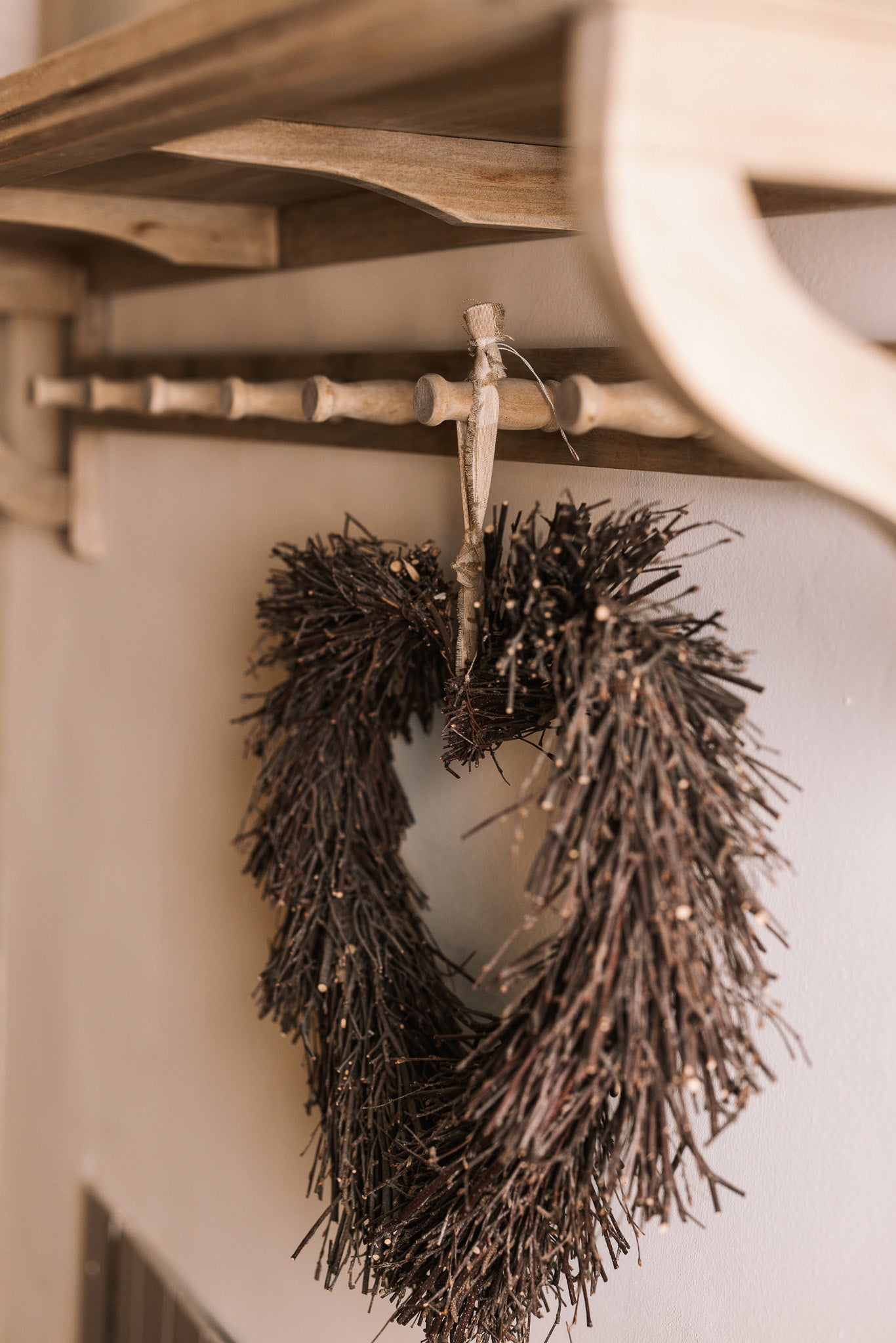 Wooden shelf with coat hooks, decorative items on shelf.