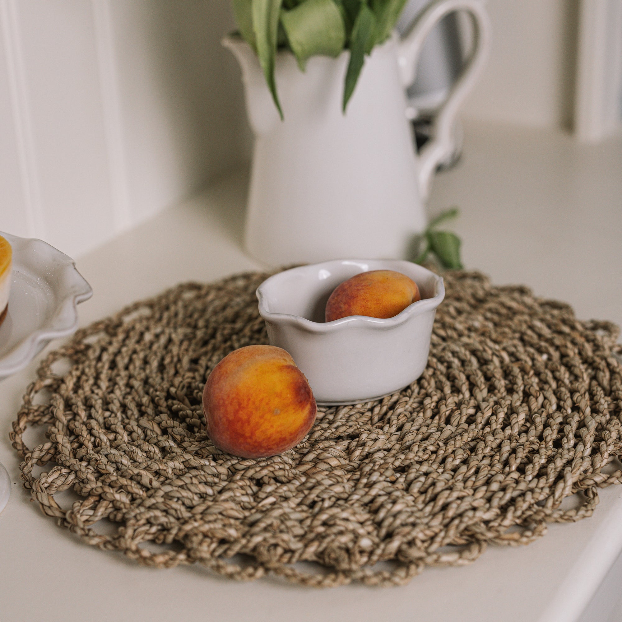 White oval ramekin dish with pie crust top with a pair of peaches.