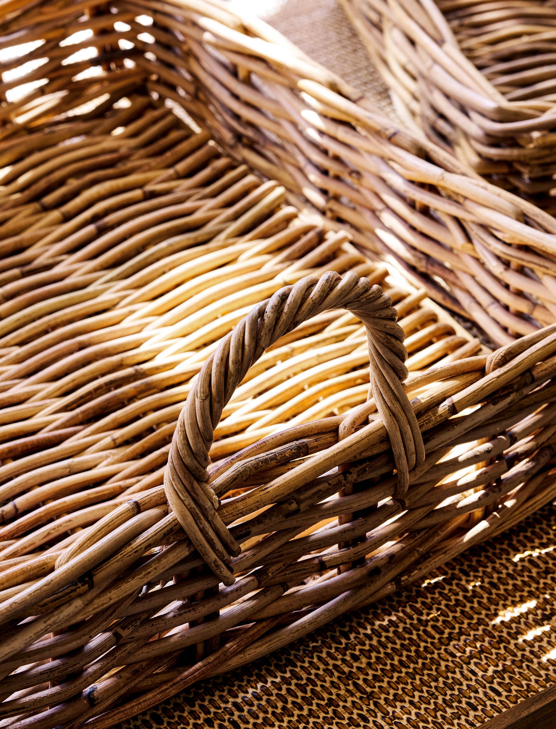 Close-up of a natural woven trays with a decorative handle.