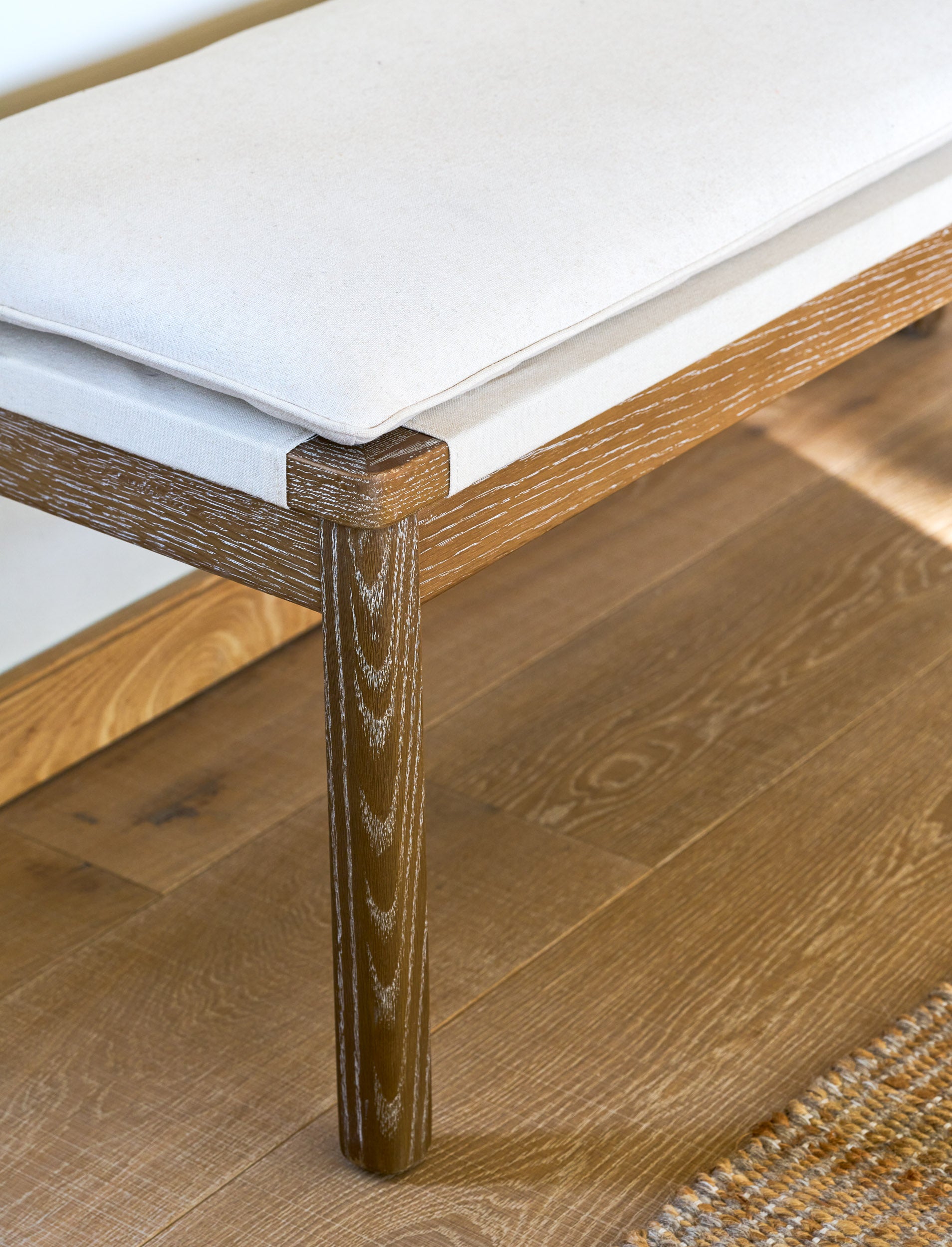 Wooden bench seating with cushions on a wooden floor