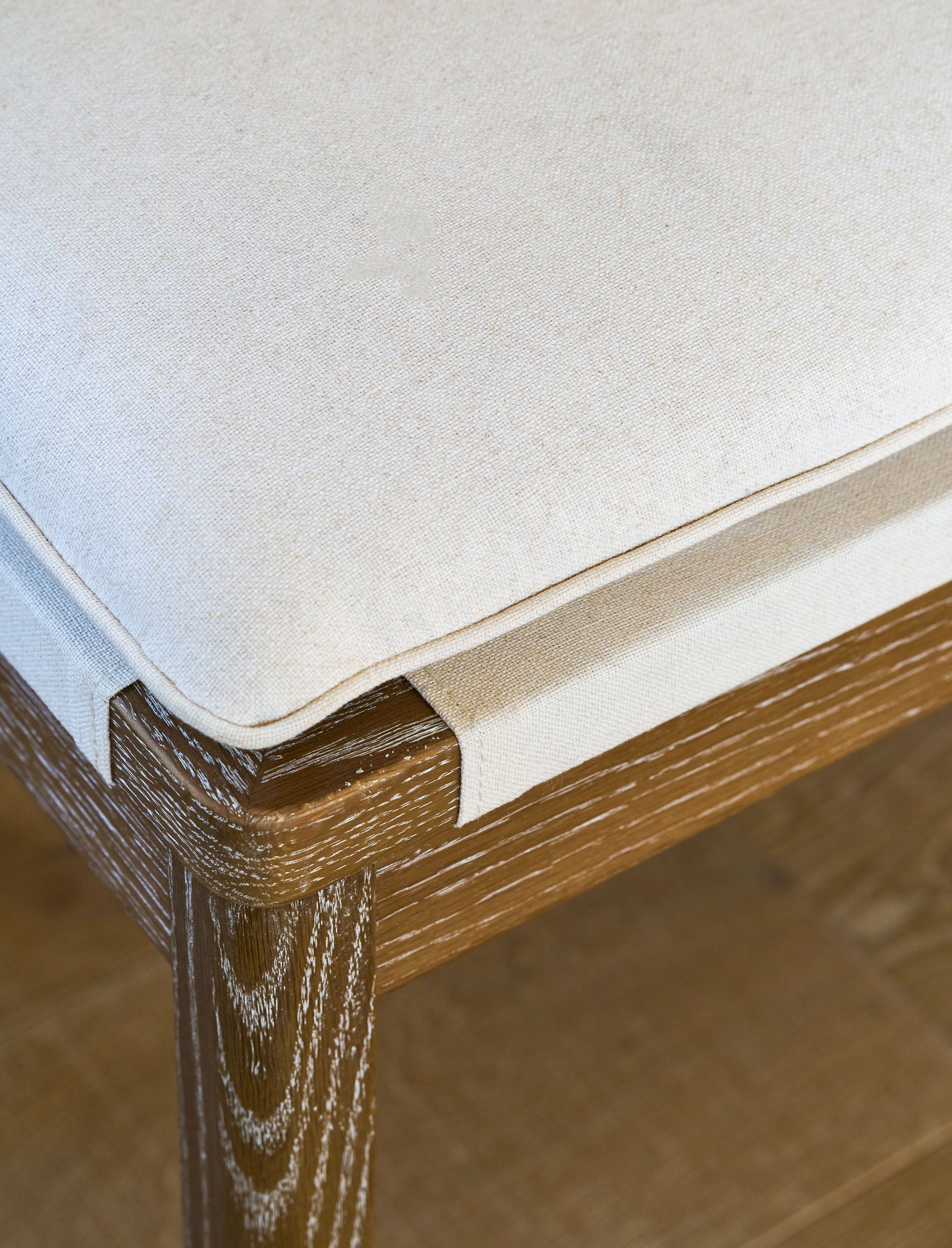 Close-up of a wooden bench seating with cushions and backrest.